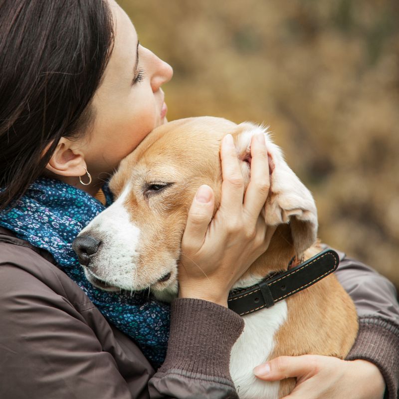 A woman lovingly hugs her dog